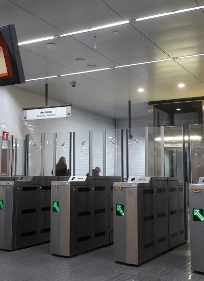 Public transportation gate access with green arrows.