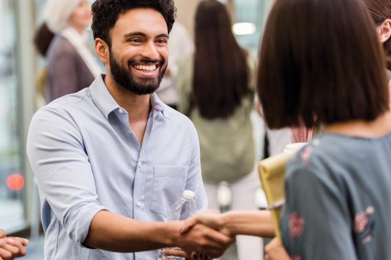 man smiling, shaking hands