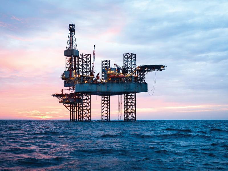 Oil rig in the ocean during sunset