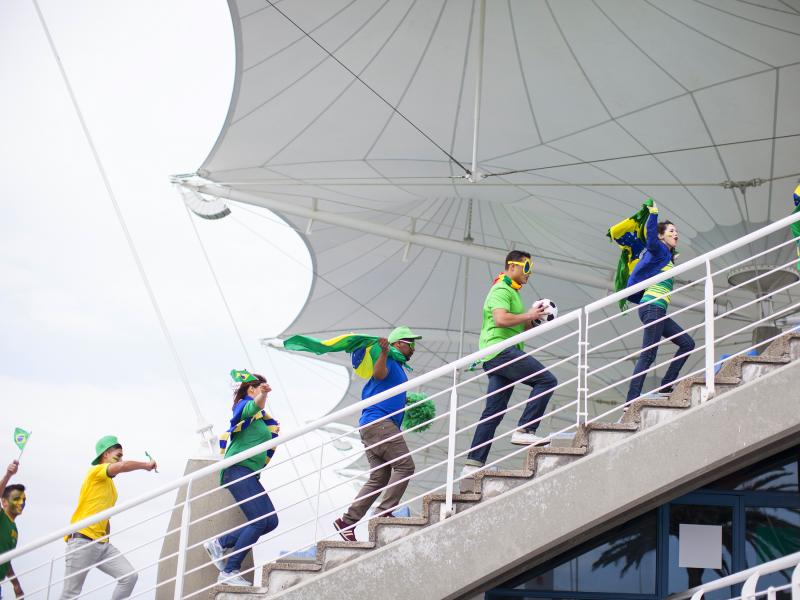 Soccer fans cheering on Brazil walks in a staircase