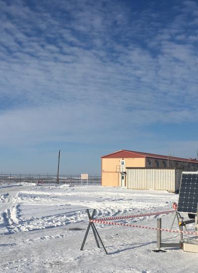 Pole-mounted security camera driven by solar energy in a snowy oil field